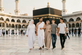 Famille multigénérationnelle musulmane marchant ensemble sur l'esplanade de la Grande Mosquée lors du pèlerinage du Hajj